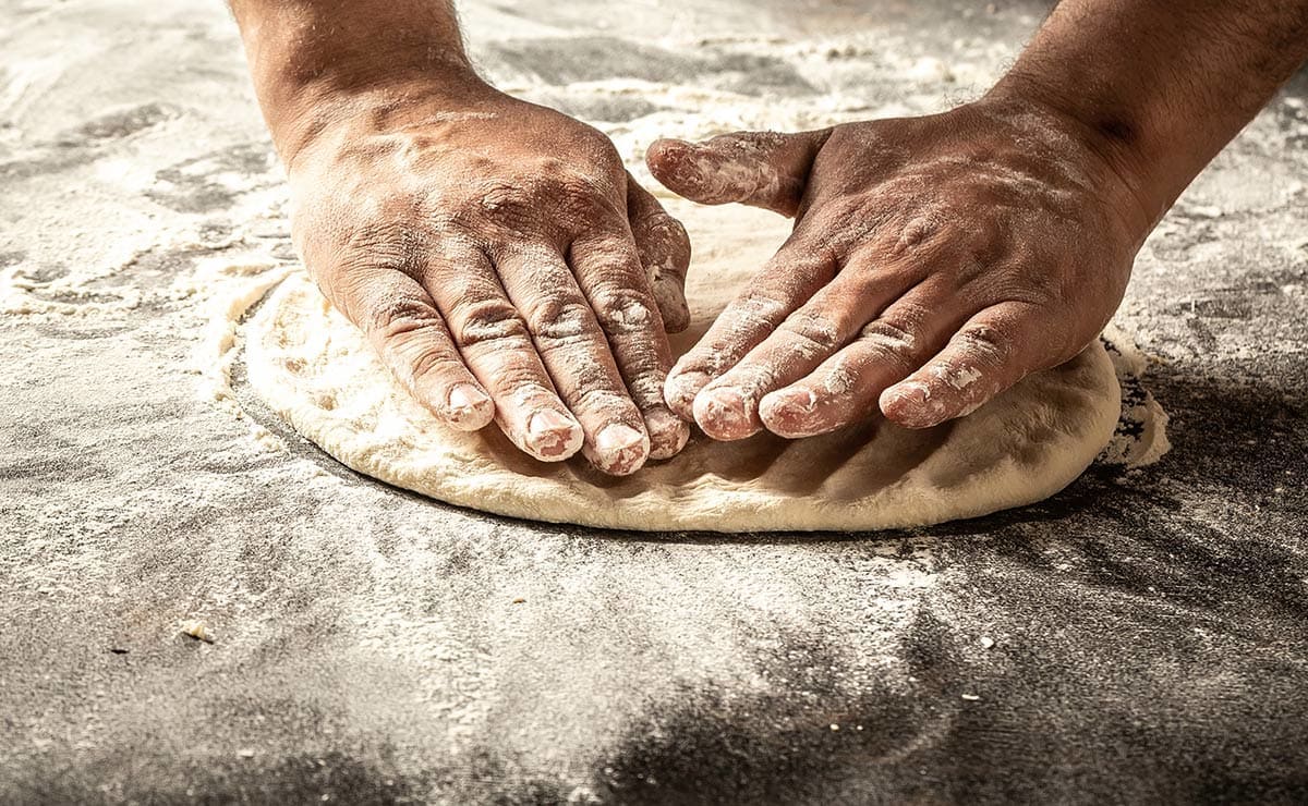 Mano amasando y estirando pizza